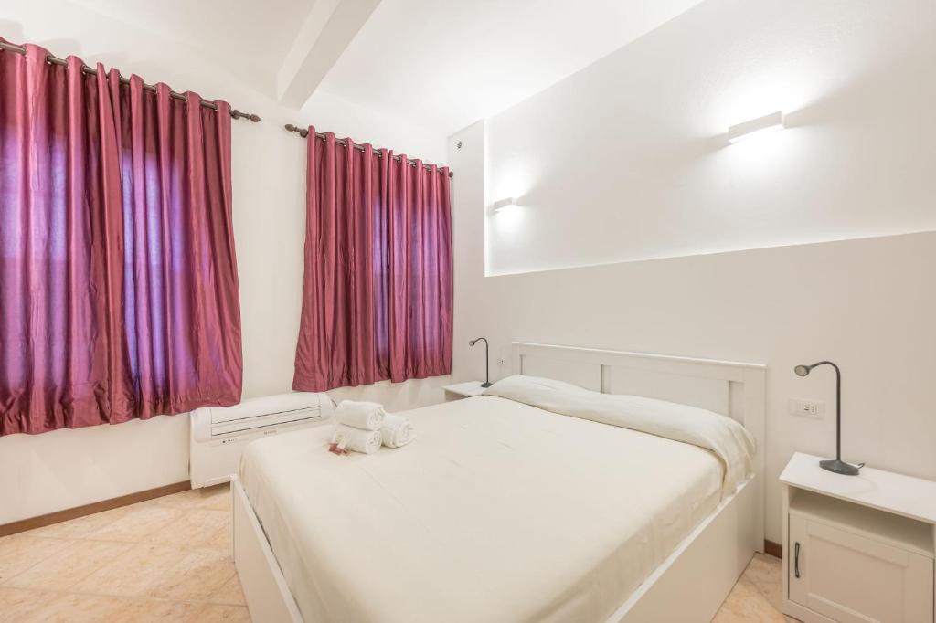 a bedroom with a white bed with a teddy bear on it at Casa Luna - vicino alla stazione dei treni in Venice