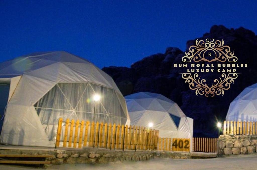 Um grupo de cúpulas com um cartaz que lê "Ryu Royal Envelope Night End" em RUM ROYAL BUBBLES lUXURY CAMP em Wadi Rum