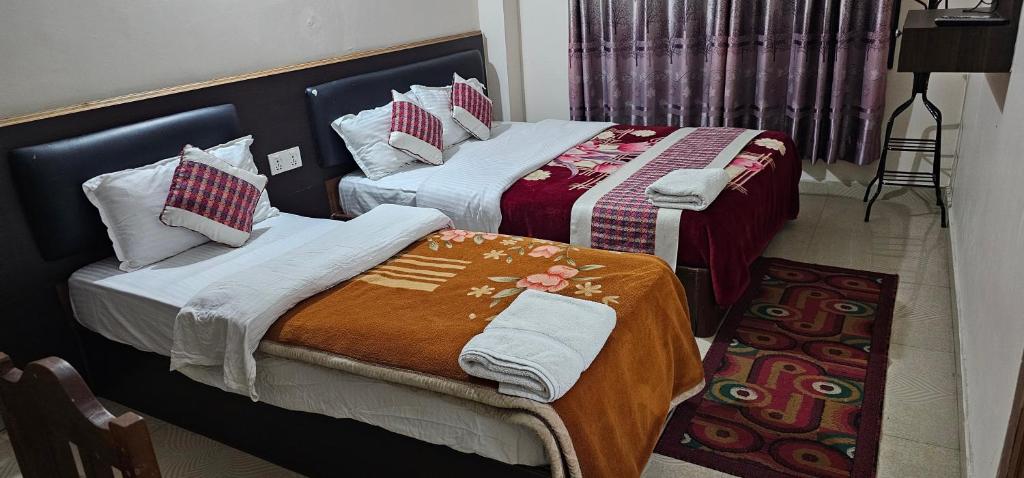 dos camas sentadas una al lado de la otra en una habitación en Hotel Simara, en Simra