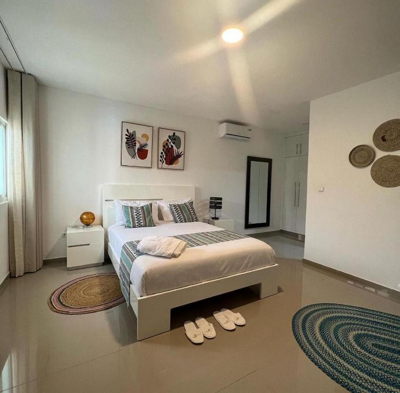 ein Schlafzimmer mit einem Bett und Hausschuhen auf dem Boden in der Unterkunft Locanda group B&B in Luanda