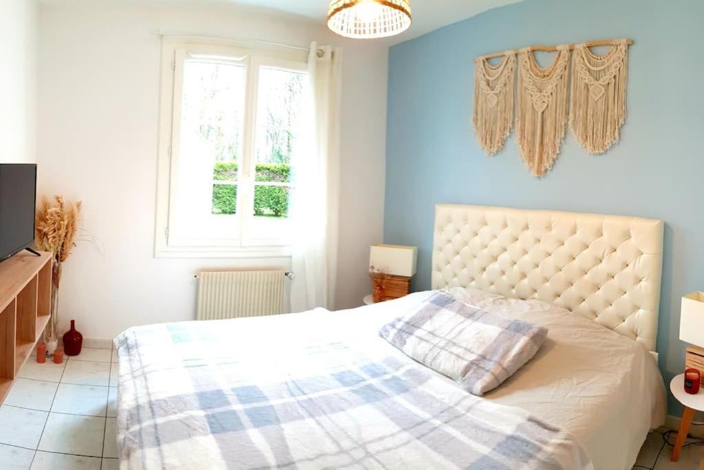 Saint-Aignan-Grand-Lieu的住宿－Appartement proche de l'aéroport de Nantes，一间卧室配有一张蓝色墙壁的床