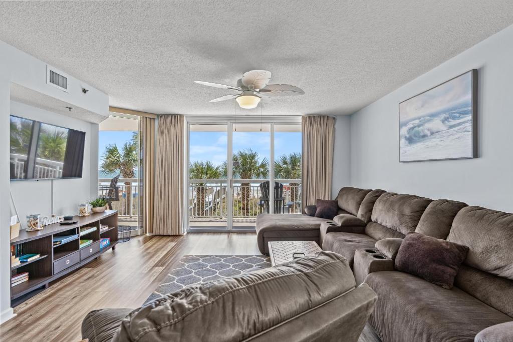 ein Wohnzimmer mit einem Sofa und einem Deckenventilator in der Unterkunft Crescent Shores N - 105 - Oceanfront-Crescent Beach Section in Myrtle Beach