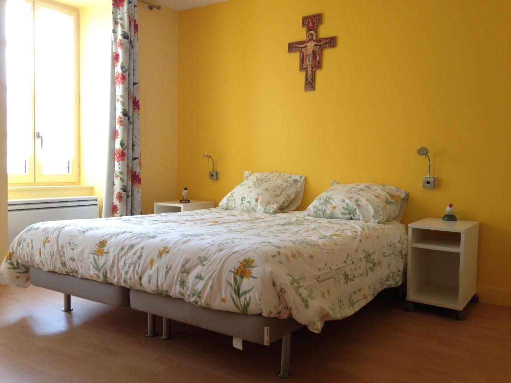 a bedroom with a bed with a cross on the wall at A MARIE ET GABRIEL in L'Ile-Bouchard