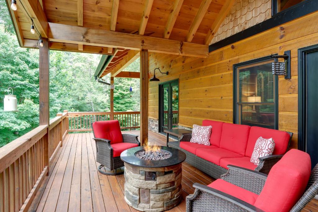 - une véranda avec un mobilier rouge et un foyer extérieur dans l'établissement Spacious Blue Ridge Cabin with Private Hot Tub!, à Blue Ridge