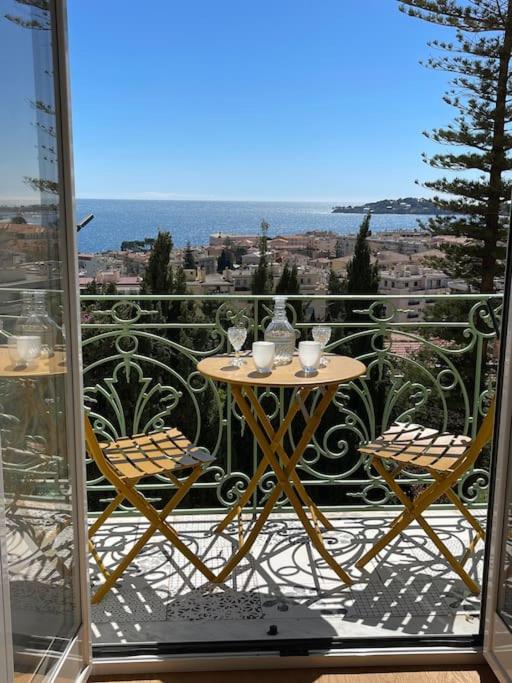 une table et des chaises sur un balcon avec vue dans l'établissement 5 mn du centre de Beaulieu., à Beaulieu-sur-Mer