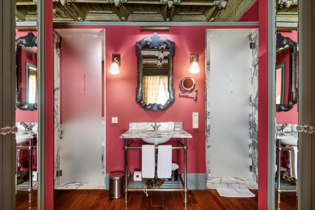 uma casa de banho com uma parede rosa e um lavatório. em M Maison Particulière Porto no Porto