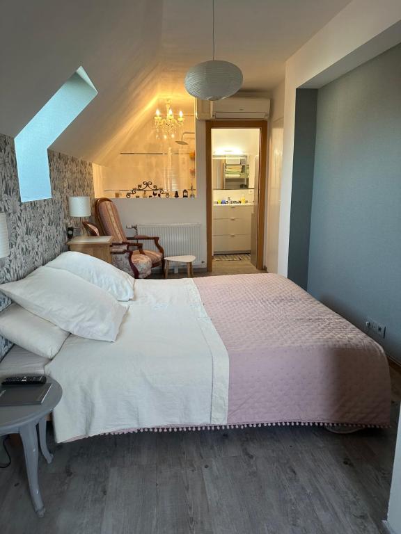 une chambre avec un grand lit blanc et un salon dans l'établissement Bienvenue chez Eve en bourgogne chambre 1, à Beaune