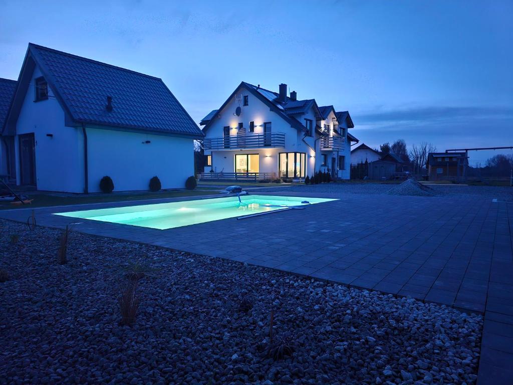 uma casa com piscina no quintal em Cichy Domek - Podgrzewany Basen, Parking, Aneks Kuchenny em Karwia