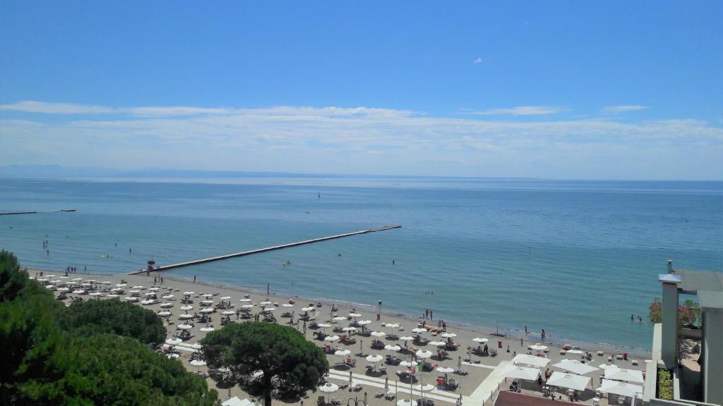 ein Strand mit vielen Sonnenschirmen und dem Meer in der Unterkunft Viale Dante in Grado