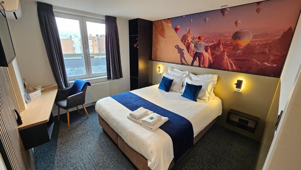 a hotel room with a bed and a painting on the wall at Elberg Hotel & Apartments in Mouscron