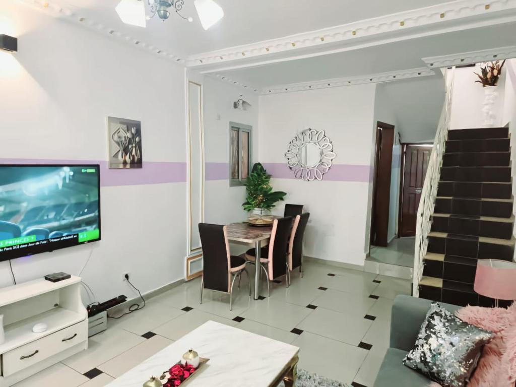 a living room with a tv and a table at GOLF HILLS BASTOS in Yaoundé