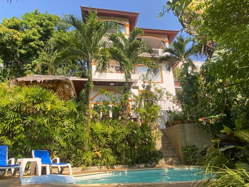 a resort with a swimming pool and two blue chairs at OASIS VILLA Karon Beach in Karon Beach