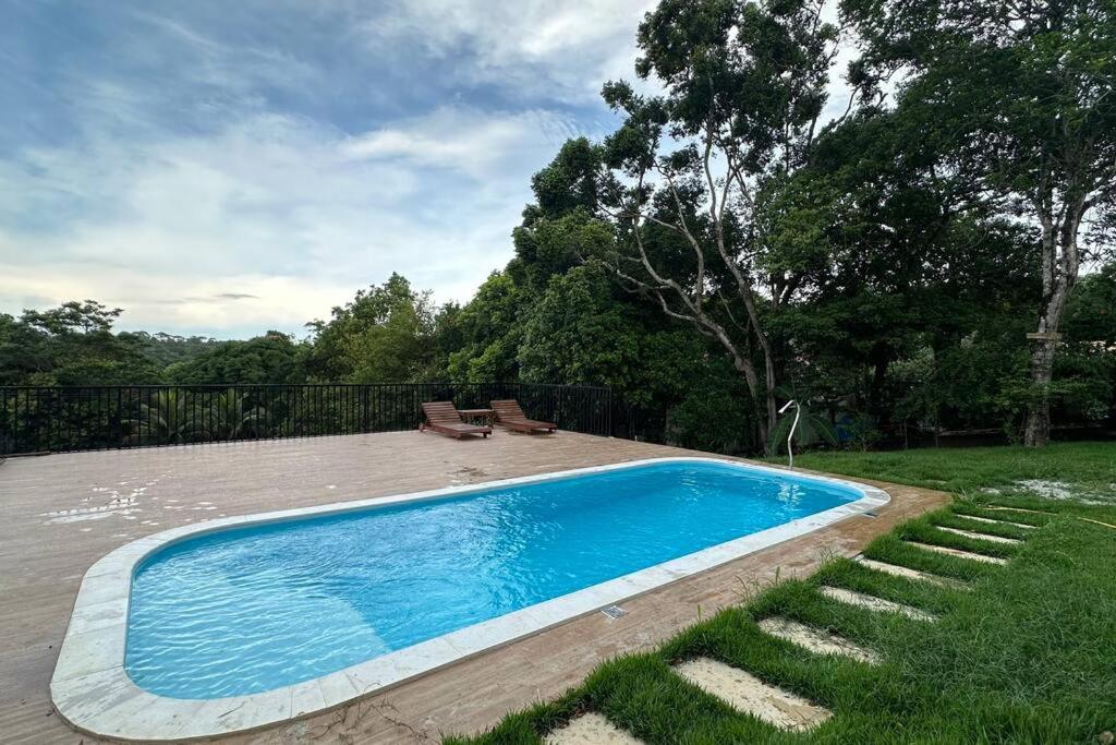 a small blue swimming pool in a yard at Casa Retiro do Congo in Vila Velha