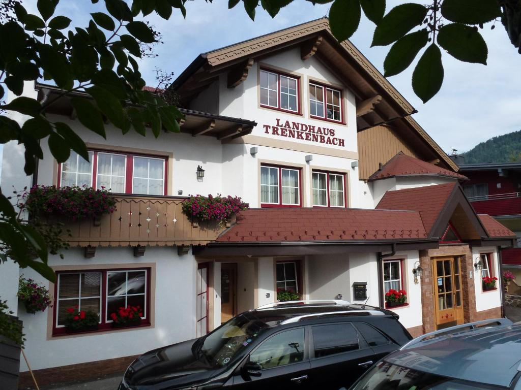 a building with a car parked in front of it at Hotel Garni Landhaus Trenkenbach in Schladming