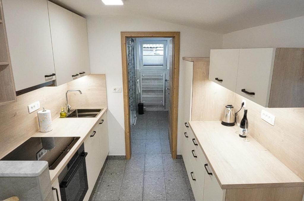 a kitchen with white cabinets and a sink at Apartment Pr'pek in Bohinj