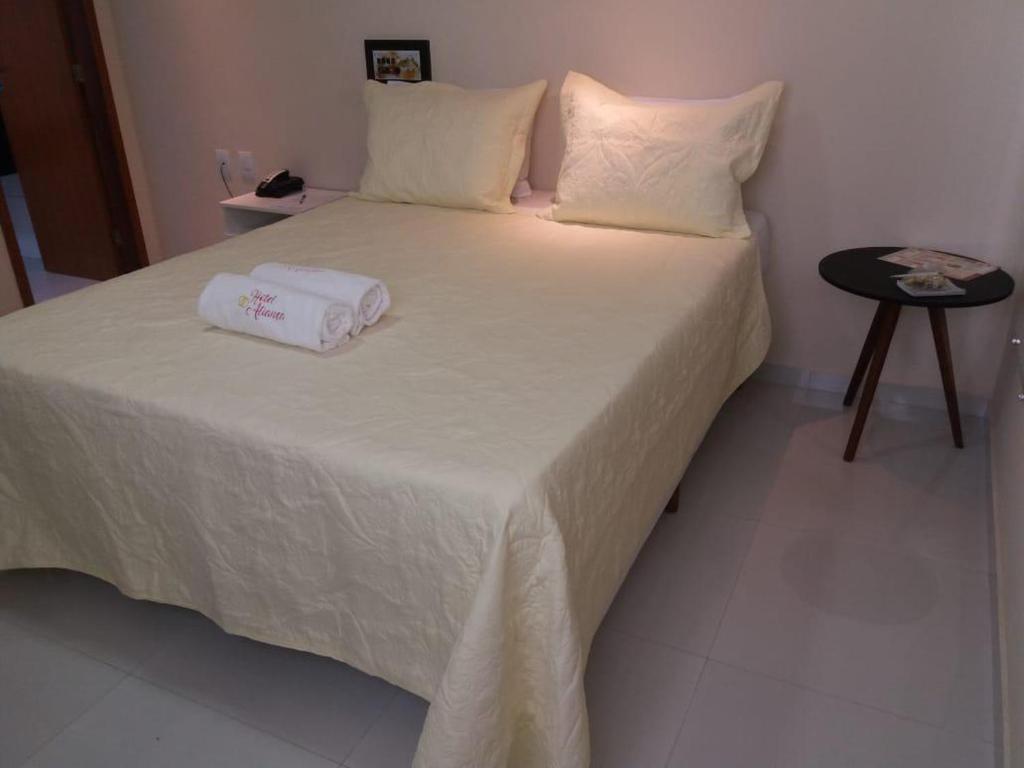 a bed with two towels sitting on top of it at Hotel Aliança in Salvador