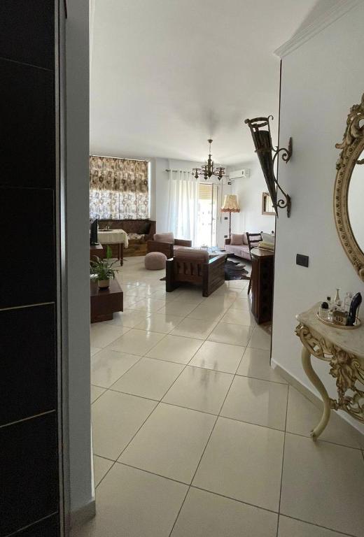 een woonkamer met een grote witte tegelvloer bij Small City living HB in Vlorë