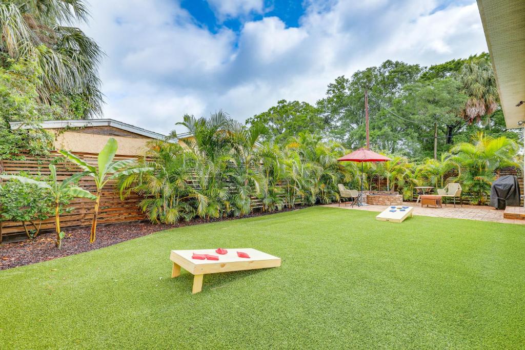 a backyard with a lawn with a table on it at Tampa Home with Fire Pit, Grill, Cornhole and More! in Tampa