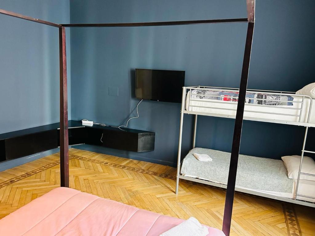 a bedroom with two bunk beds and a tv at Maya Rooms in Milan