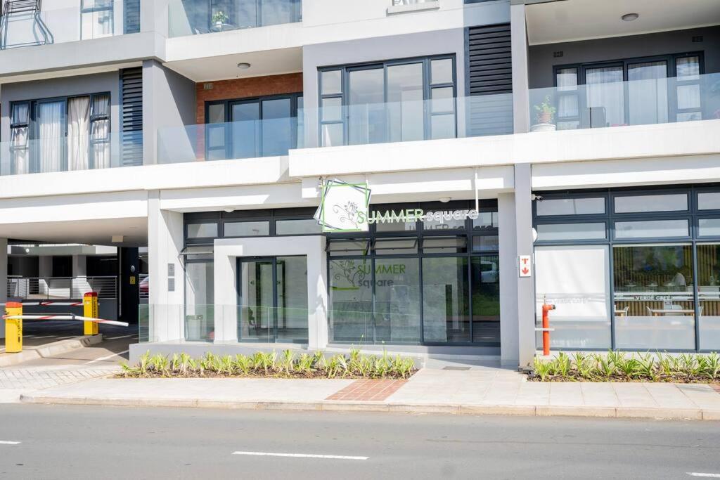 un edificio con un cartel al costado de una calle en Summer Square, Umhlanga Ridge, en Durban