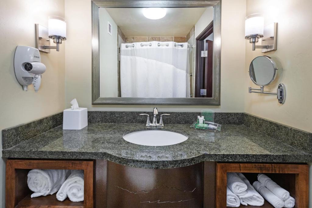 a bathroom with a sink and a mirror and towels at Holiday Inn & Suites Durango Downtown by IHG in Durango