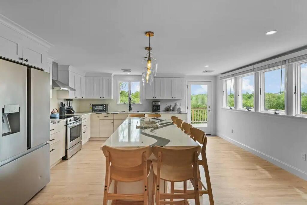 a large kitchen with a table and chairs and windows at Little Creek Retreat - RIBryan Property in Middletown