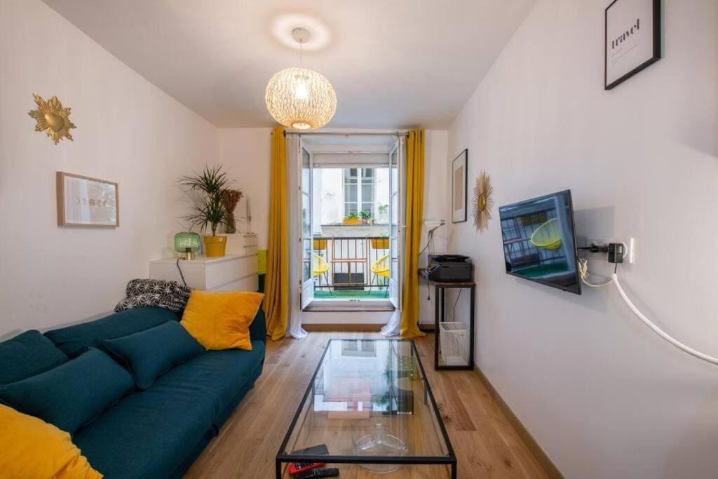 un salon avec un canapé bleu et une table en verre dans l'établissement Appartement cosy avec terrasse, à Paris
