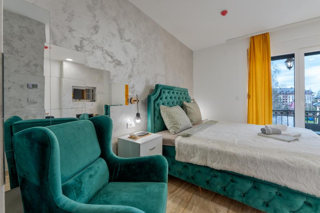 een slaapkamer met een groen bed en een stoel bij M&L Apartman Zlatibor in Zlatibor