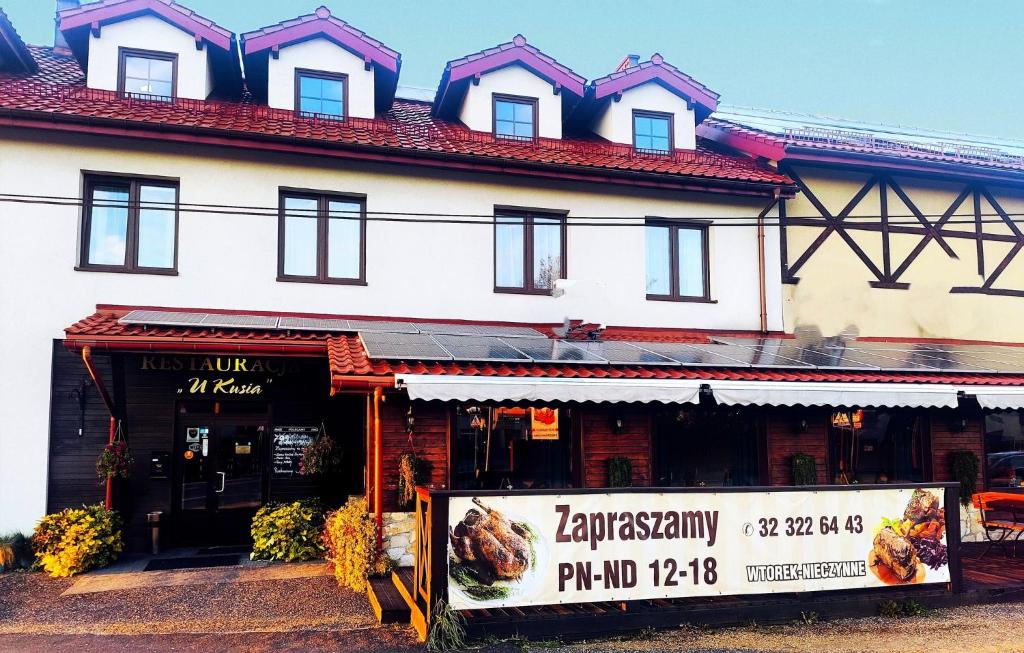 een gebouw met een bord ervoor bij Pokoje gościnne Restauracja u Kusia in Mikołów
