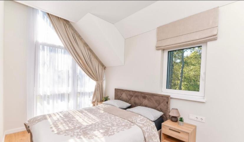 a bedroom with a bed and a window at Sesiu Vilos @ Kunigiskes in Palanga