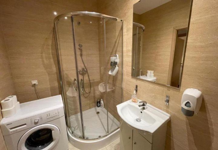 La salle de bains est pourvue d'une douche, d'un lavabo et d'un lave-linge. dans l'établissement Poznań park, à Poznań