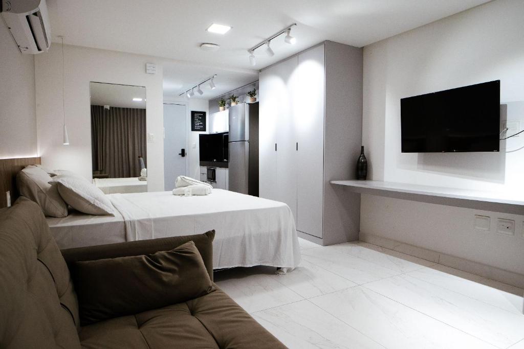 ein Wohnzimmer mit einem Sofa und einem TV an der Wand in der Unterkunft Unity - Cabo Branco in João Pessoa
