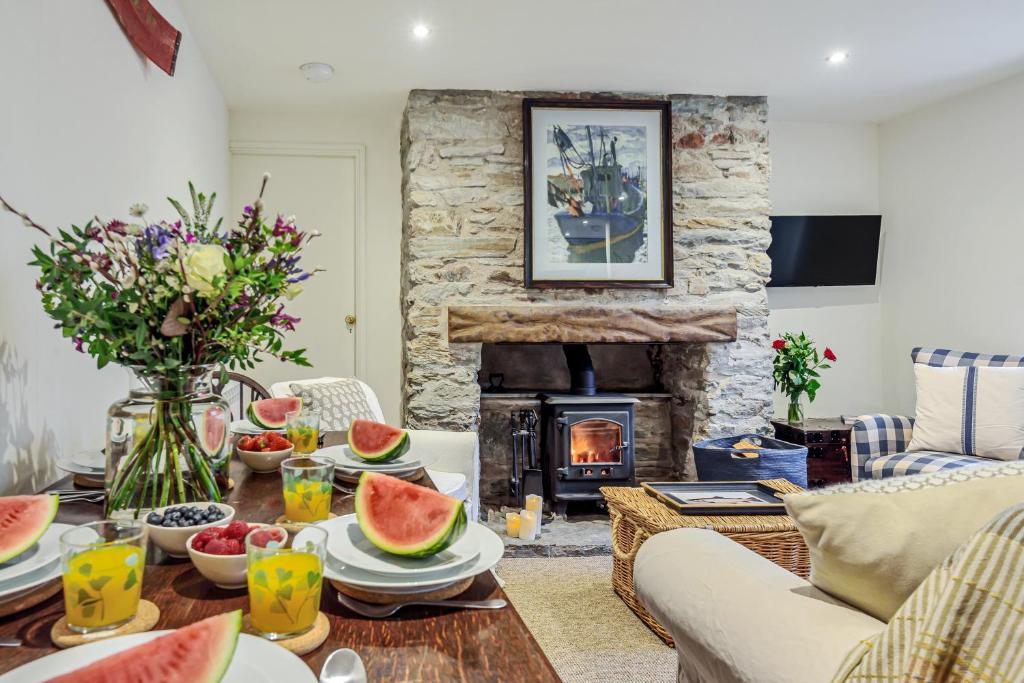 ein Wohnzimmer mit einem Tisch mit Wassermelonen darauf in der Unterkunft Cottage in Tranquil Hamlet in Salcombe