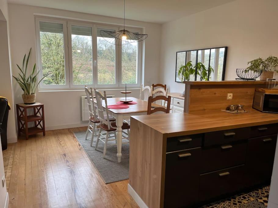 une cuisine et une salle à manger avec une table et des chaises dans l'établissement Maison entre terre et mer, à Dinéault