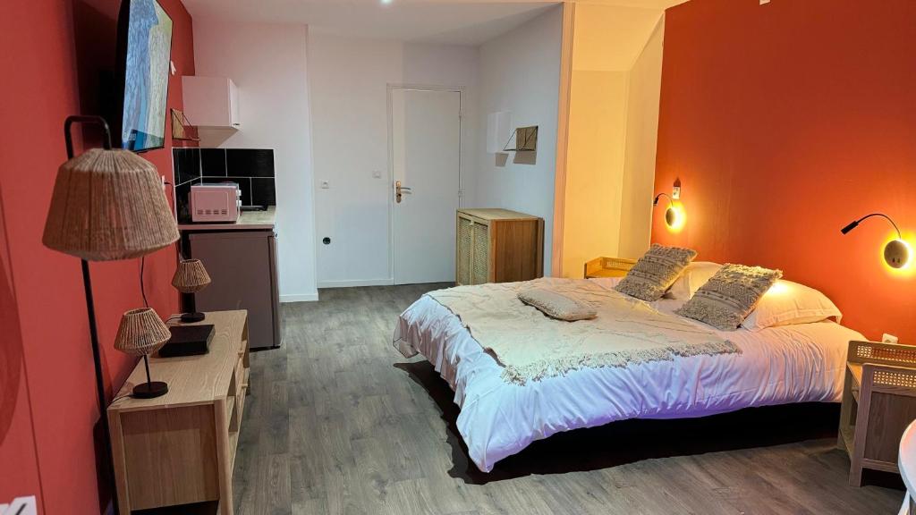 a bedroom with a large bed with an orange wall at Balnéo Blanche Porte in Tourcoing