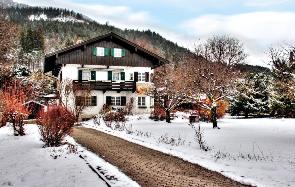 una casa en la nieve con un camino delante en Ferienwohnung in Garmisch-Partenkirchen mit Terrasse - b60502, en Garmisch-Partenkirchen