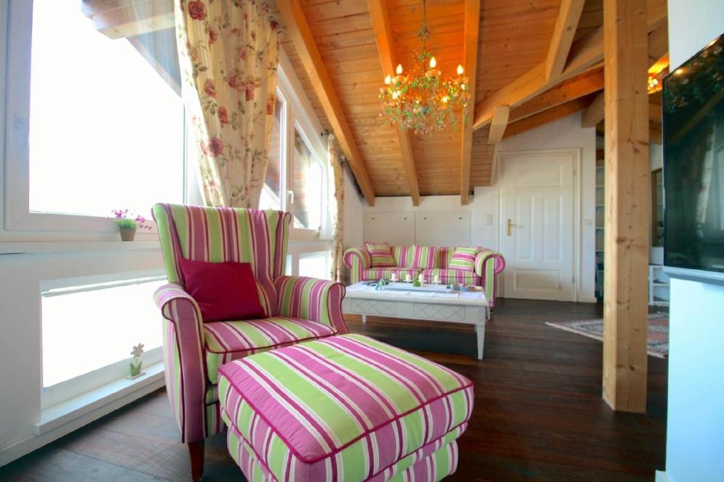 ein Wohnzimmer mit Stühlen, einem Tisch und einem Kronleuchter in der Unterkunft Tolle Wohnung in Breitenau mit Kleinem Garten in Garmisch-Partenkirchen