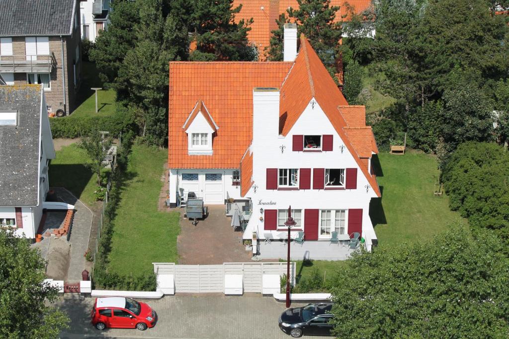 een luchtzicht op een huis met een oranje dak bij B&B Villa Fernadine in De Haan