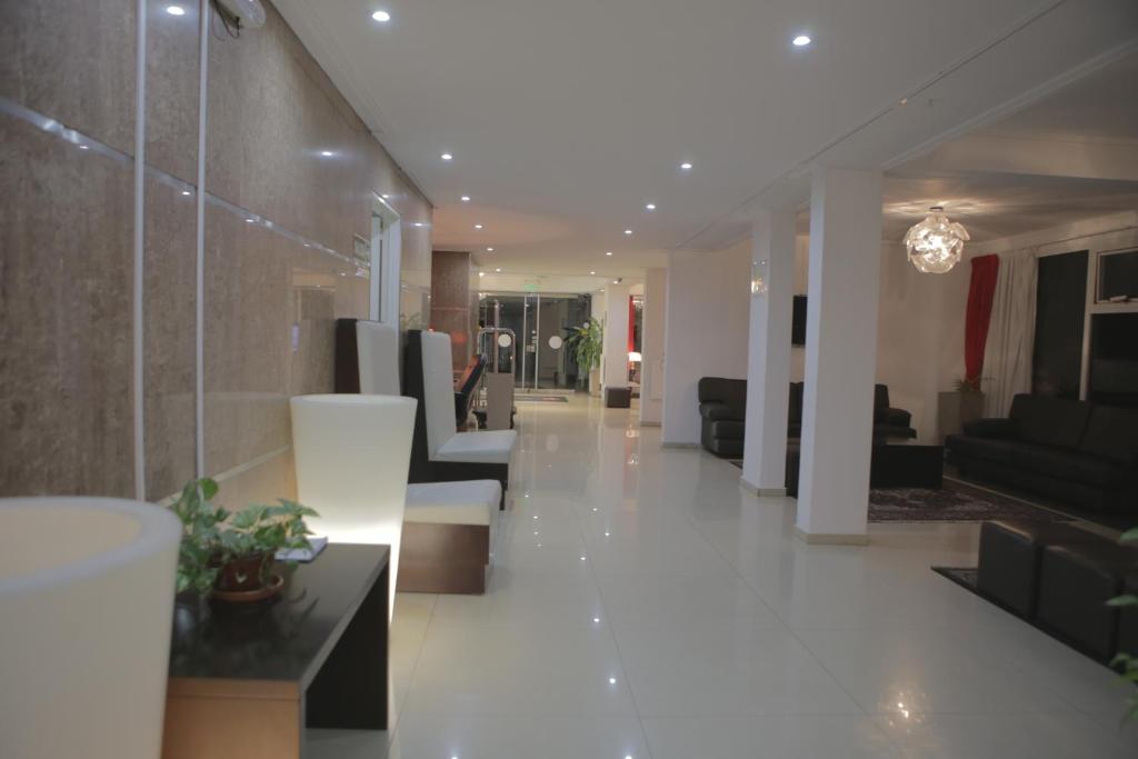 een woonkamer met witte vloeren en een lobby bij Pampa Plaza Hotel in Buenos Aires