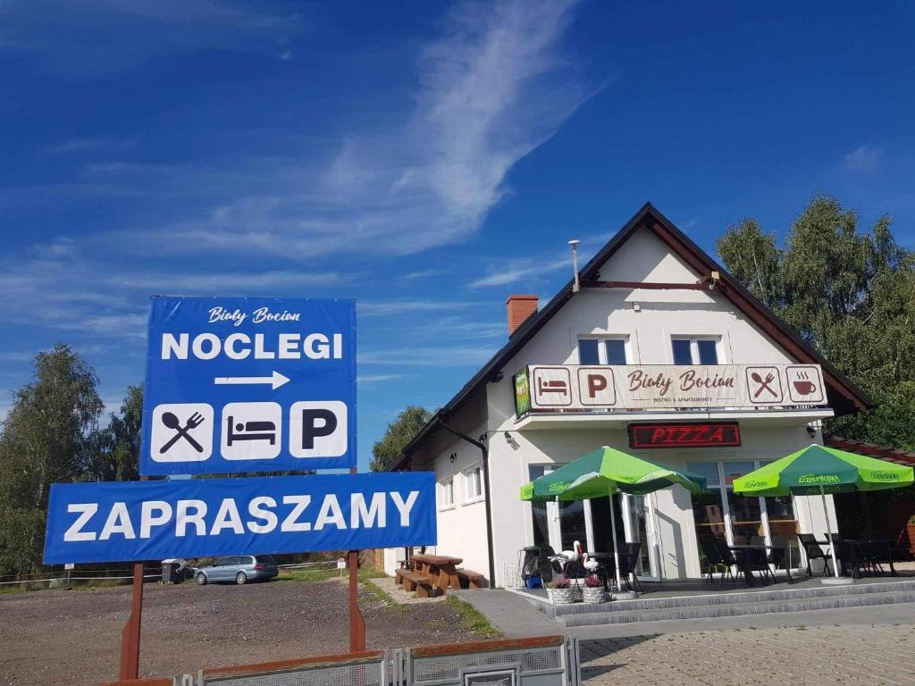 ein Gebäude mit einem Schild davor in der Unterkunft Biały Bocian in Stegers
