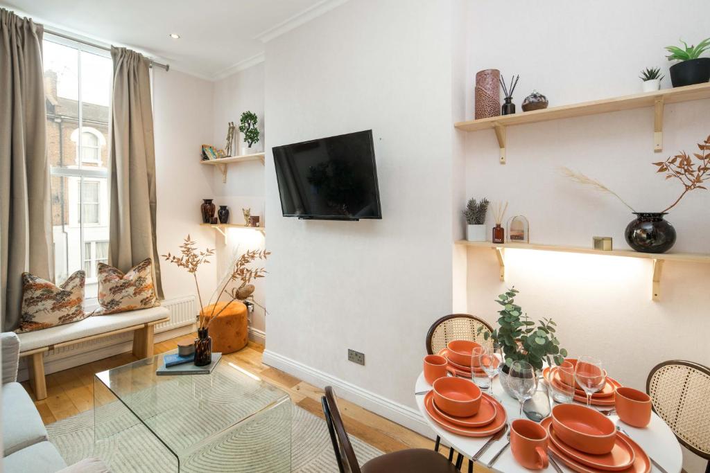 a dining room with a table with orange dishes on it at Charming 1-Bed Apartment in London in London