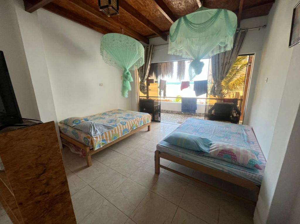 1 dormitorio con 2 camas y ventana en HABITACION FRENTE AL MAR, en Lobitos