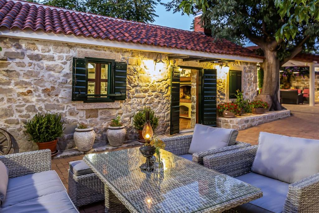 patio ze stołem i krzesłami oraz budynek w obiekcie Heritage Hotel & Estate Raznjevica Dvori AD 1307 w mieście Polača