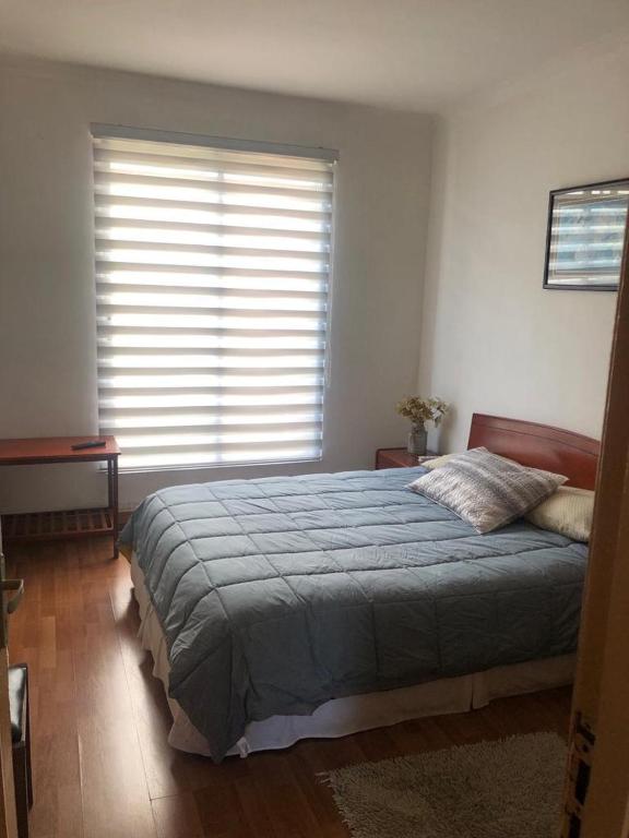 een slaapkamer met een groot bed en een raam bij San Sebastian in Concepción