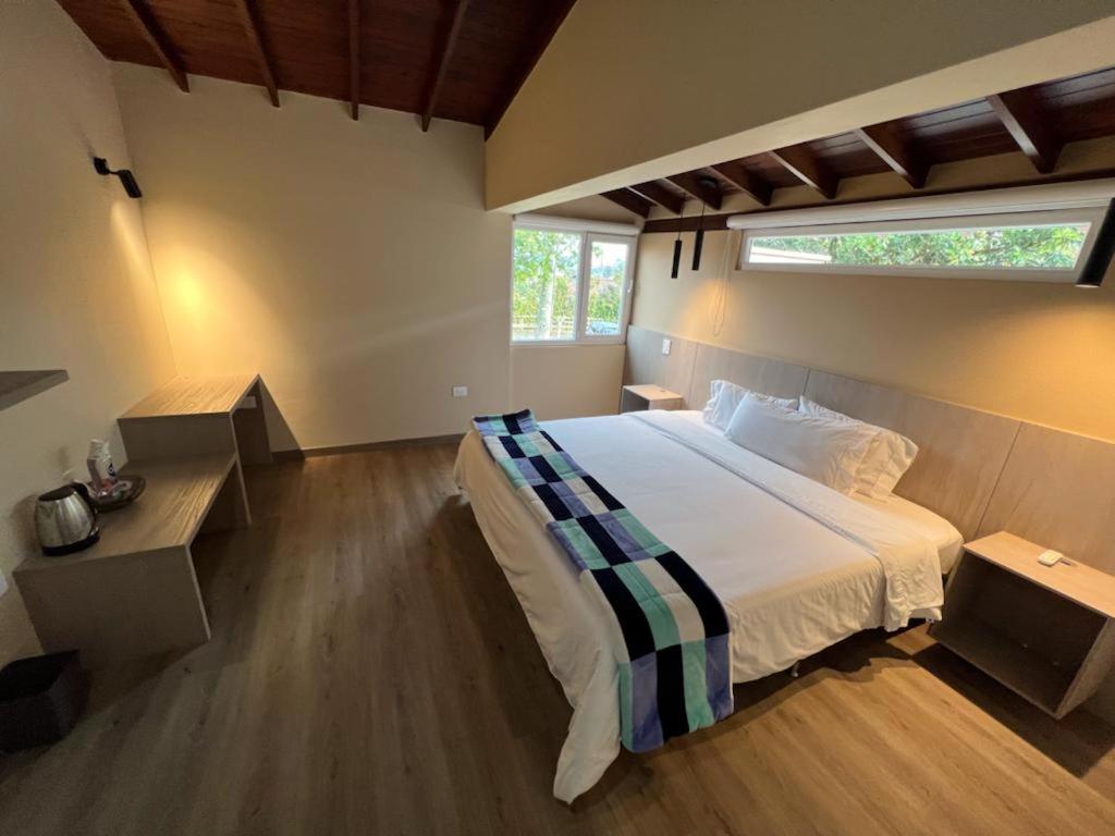 a bedroom with a large bed and a window at Hotel & Golf Isak Aeropuerto in Rionegro