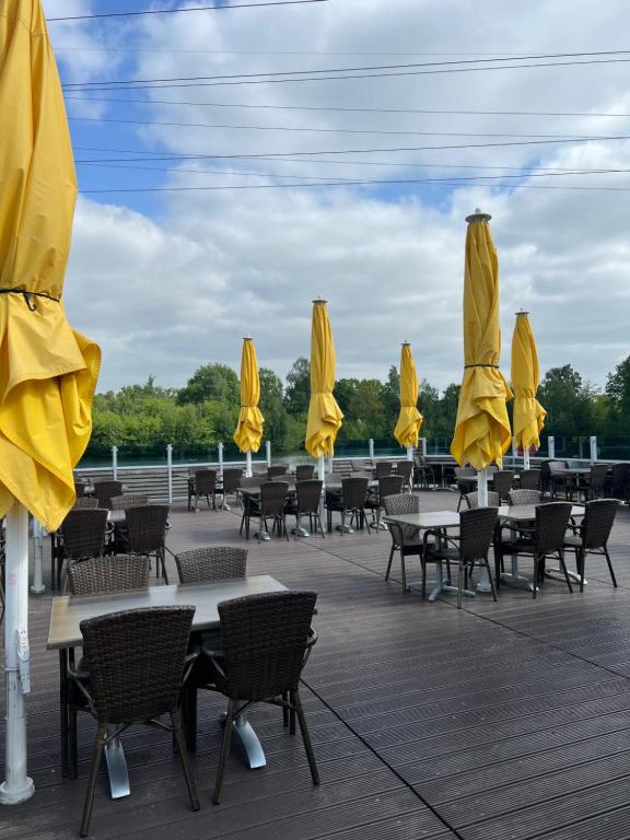 a row of tables and chairs with yellow umbrellas at Cottage & Garden & Sauna am See in Wettringen