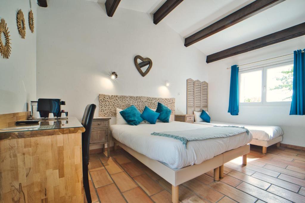 a bedroom with a bed with blue pillows at Mas De Calabrun in Saintes-Maries-de-la-Mer