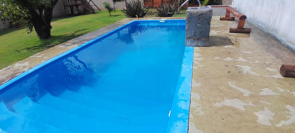 una piscina de agua azul en un patio en Mi Quincho Cañuelas en Cañuelas