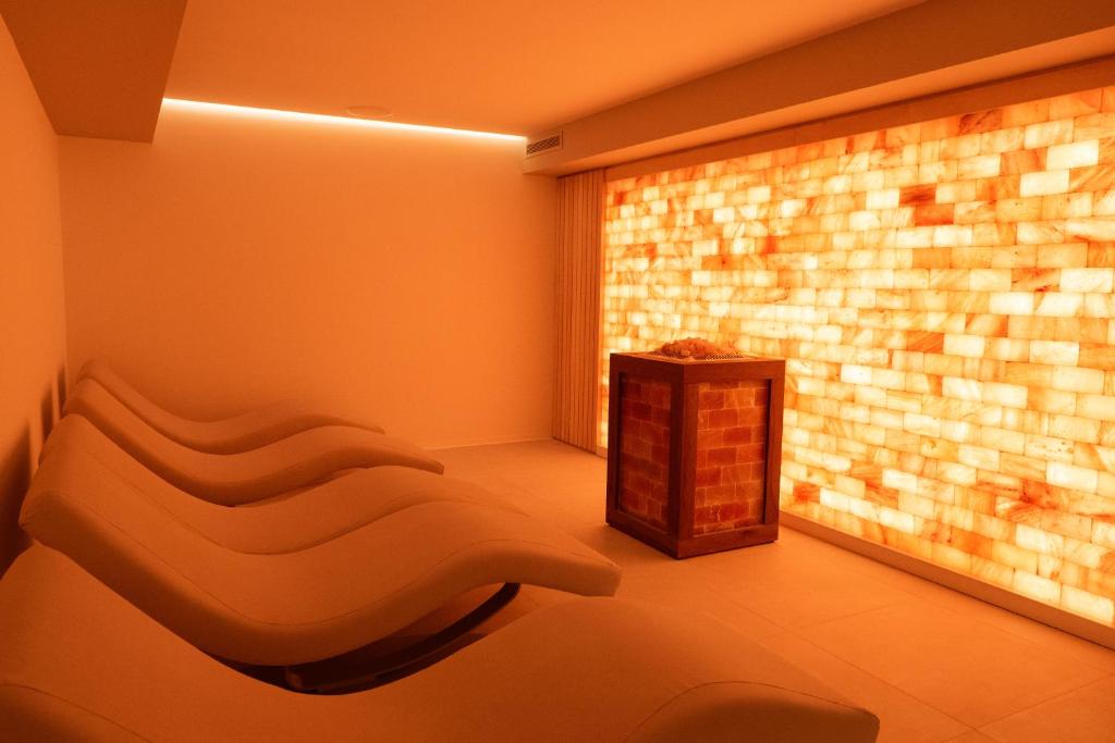 a room with a couch in front of a brick wall at Hotel President in Lignano Sabbiadoro