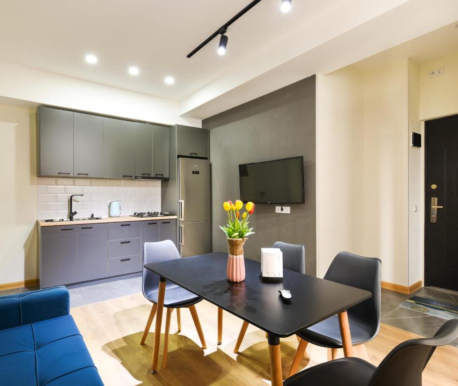 Una cocina y un comedor con mesa y sillas. en Cozy room apartment, en Tiflis